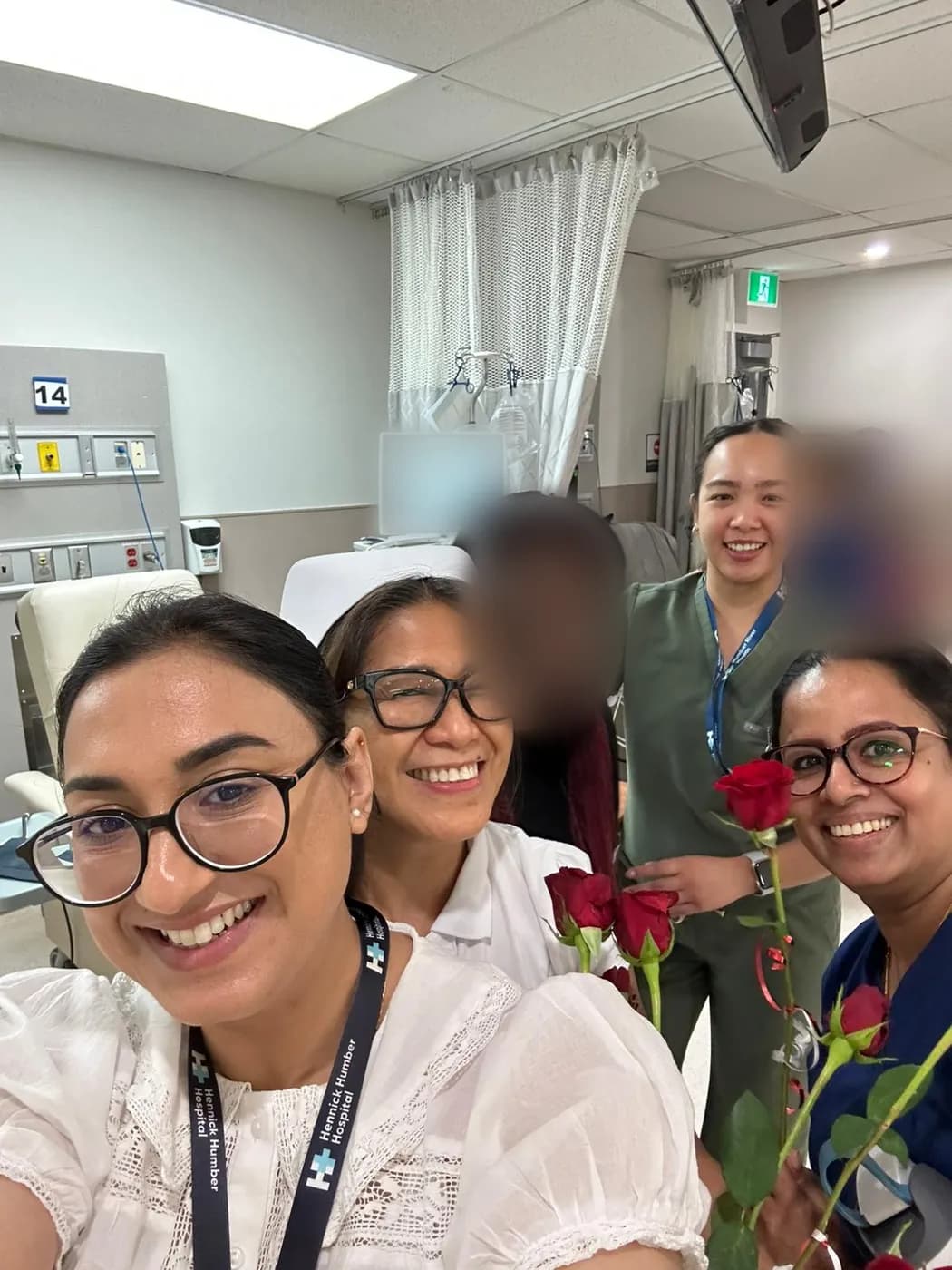 Jasraj with nursing colleagues holding roses in a dialysis unit