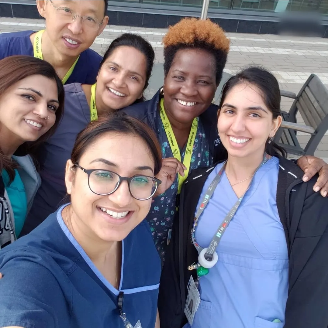 Jasraj taking a selfie with fellow nurses wearing RN Proud lanyards